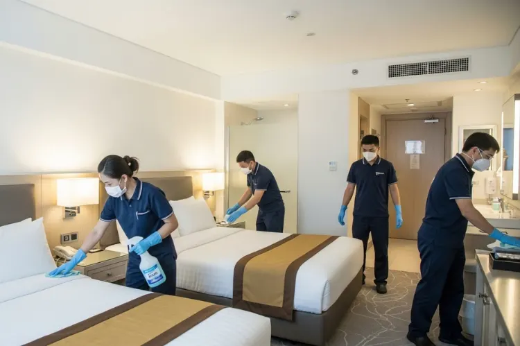 Hotel room being sanitized by cleaning staff.