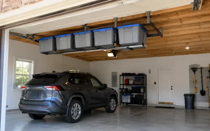 Clean garage with overhead gray storage totes and one tote slid out above a parked car.